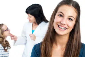 Patient smiling with braces during a visit, representing orthodontic care for adults and growing patients