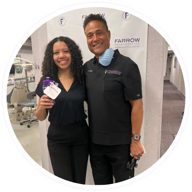 Dr. Farrow smiling with a patient holding a reward at Farrow Orthodontics.