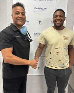 Dr. Farrow shaking hands with a smiling patient at Farrow Orthodontics.