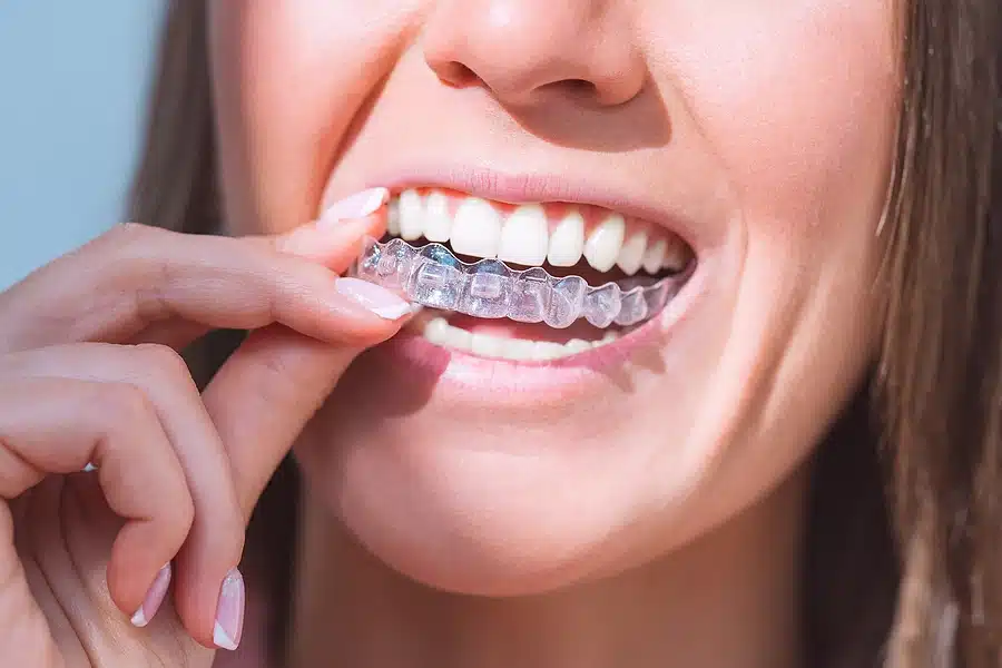 Ardmore PA patient holding Invisalign aligners at Farrow Orthodontics